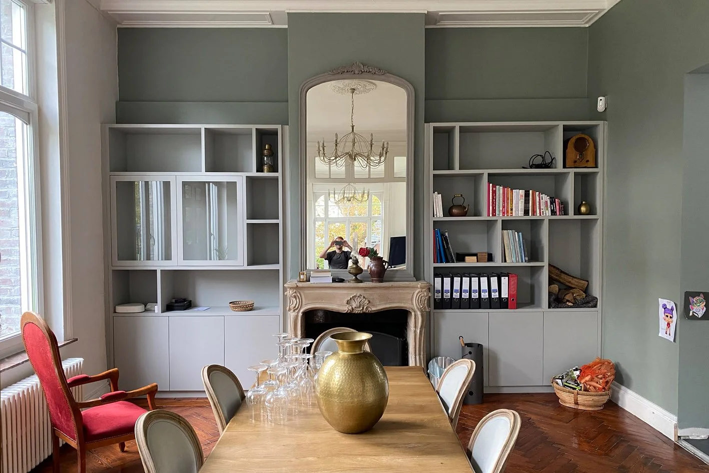 Salle à manger élégante avec table, bibliothèque, chaise rouge